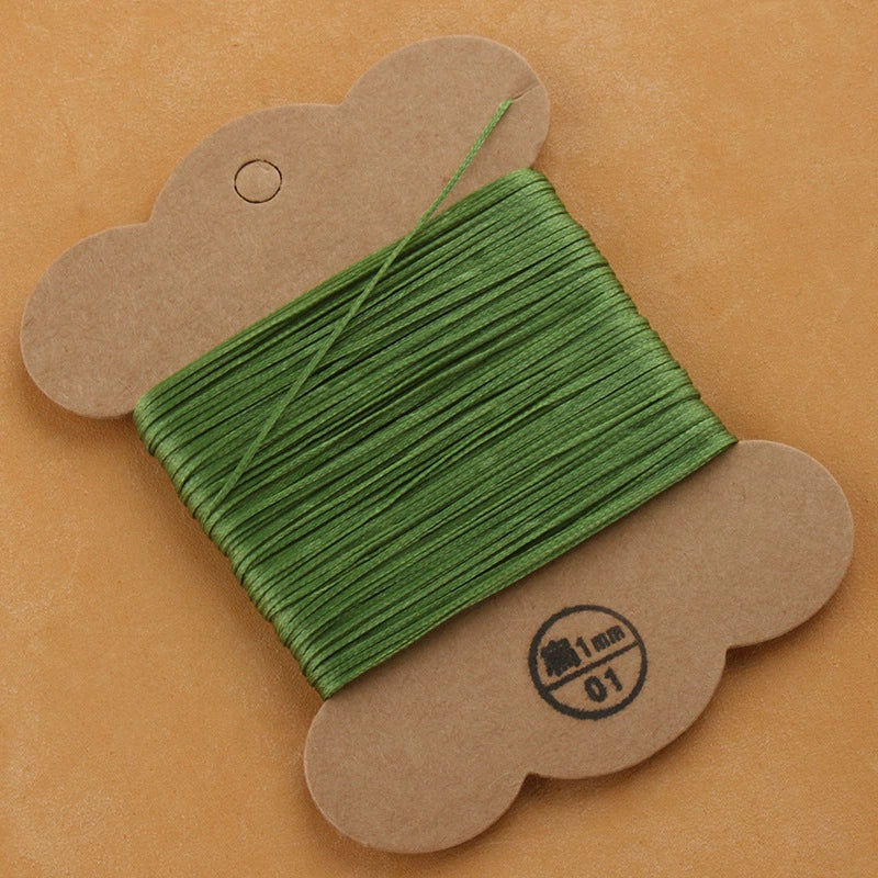 Waxed polyester thread spool in bright green on cardboard card