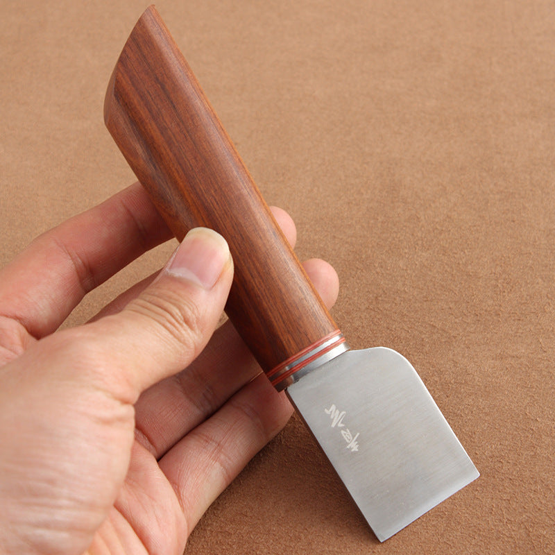 Thumb knife grip close-up: rosewood handle with silver ring and 36mm steel blade