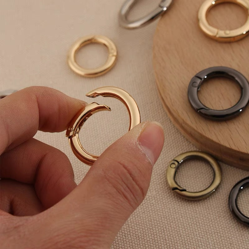 Gold metal spring open split ring held by hand for bag or leathercraft hardware