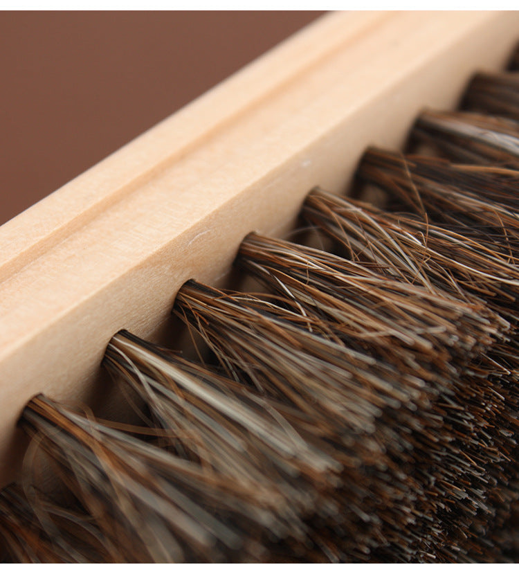 Leather care horsehair brush with light wooden handle and dense brown bristles