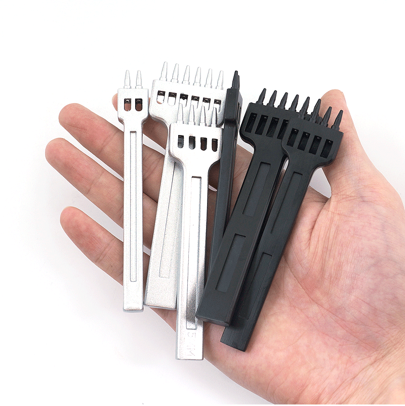 Leather hole punch set held in hand, mix of silver and black punch bars