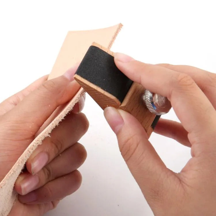Leather sanding block with black abrasive pad, held between hands