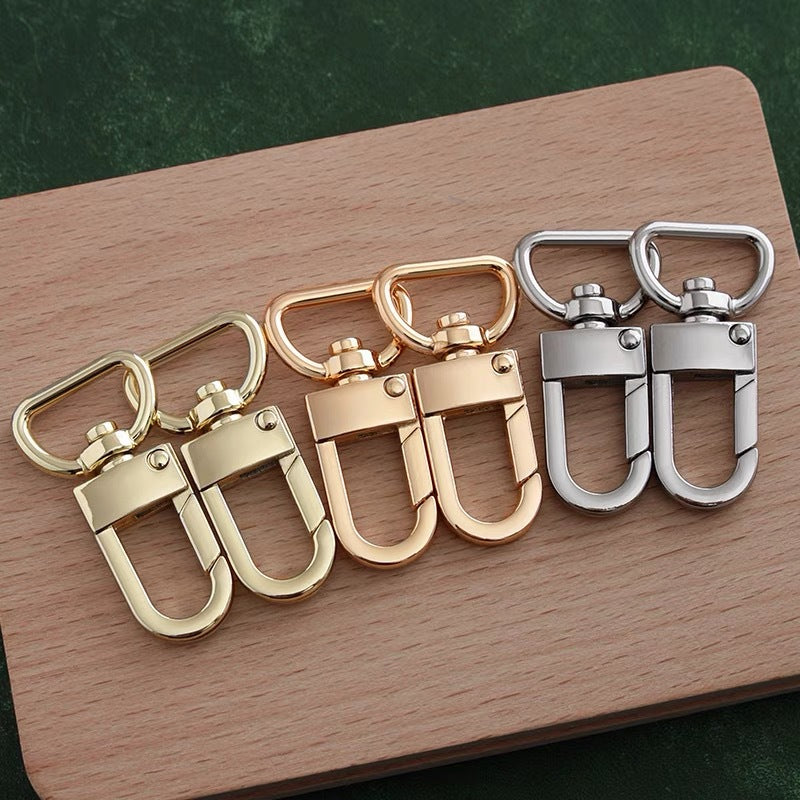 Set of metal swivel snap hooks with latch, mixed gold and silver finishes.