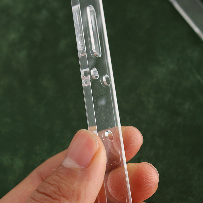 Hand holding clear acrylic belt hole punch guide with punched hole and slot