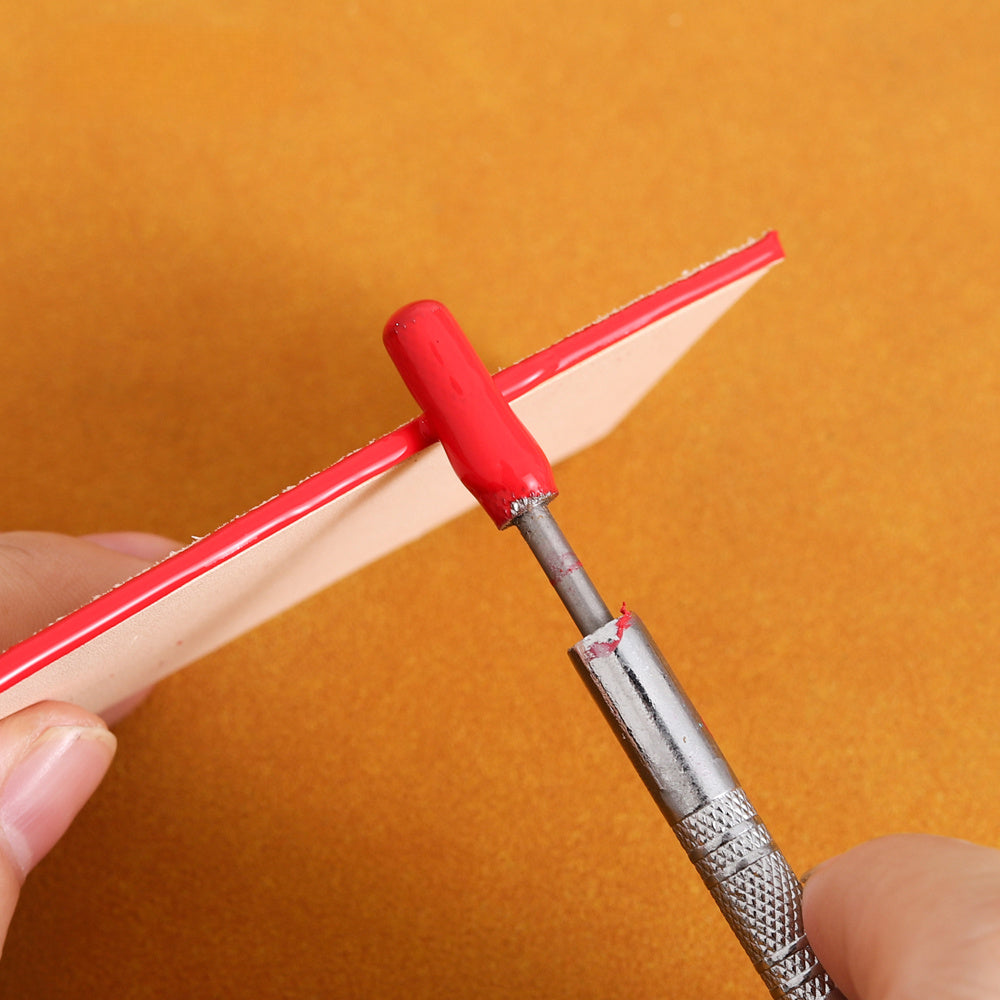 Leather edge oil pen spreading red oil along leather edge with red nozzle tip