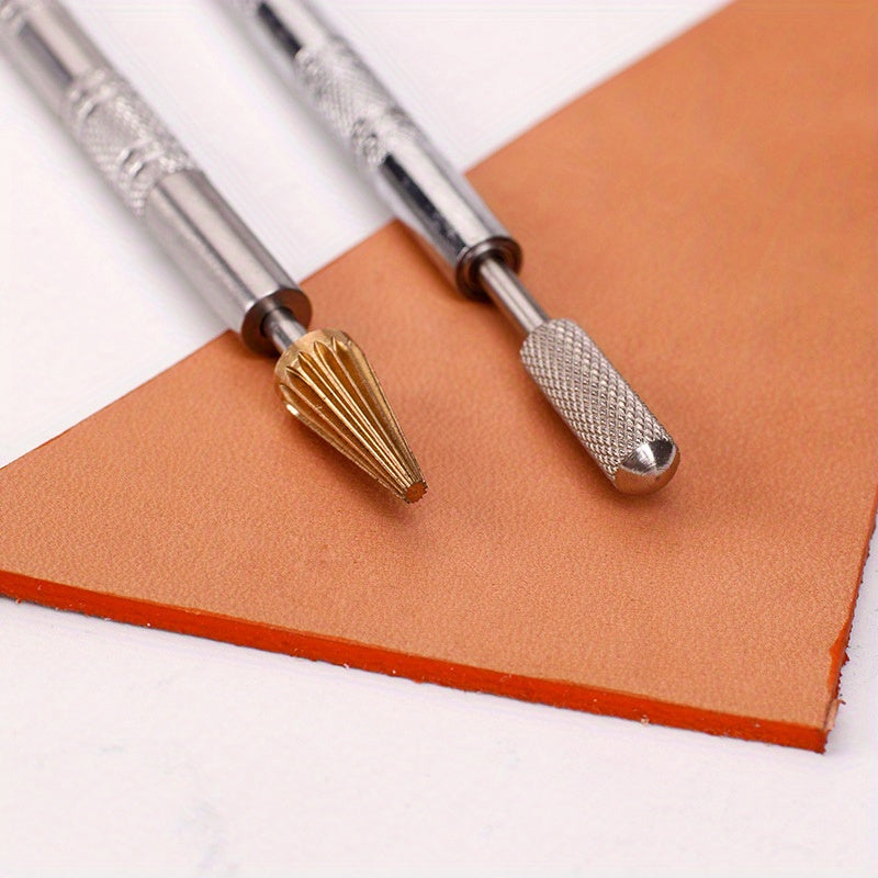 Leather edge oil pen tips on tan leather: gold conical and silver rounded applicators