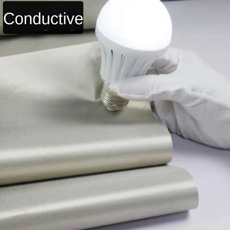 Silver-gray shielding fabric sheets with gloved hand and bulb over the material