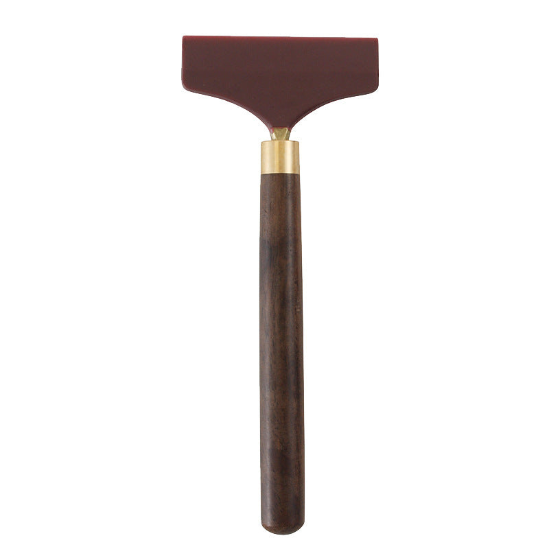 Glue scraper spreader tool with brown wooden handle and maroon silicone head
