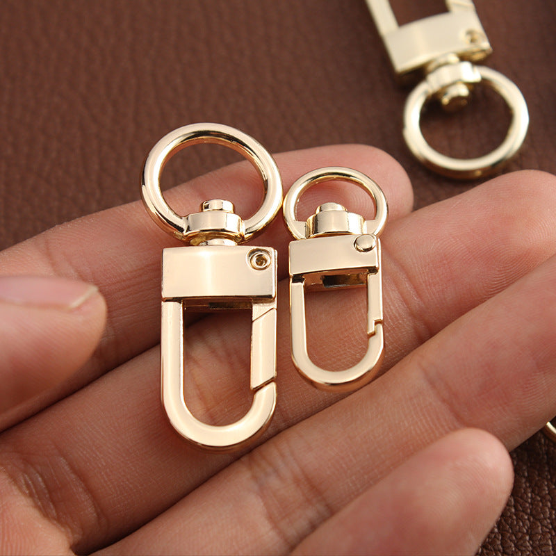 Gold swivel hook bag clasp hardware, close-up of two clips