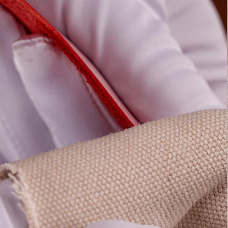 Beige canvas cloth polishing a red leather edge