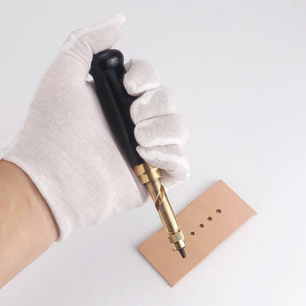Leather punch tool held in a glove, inserting a punch bit