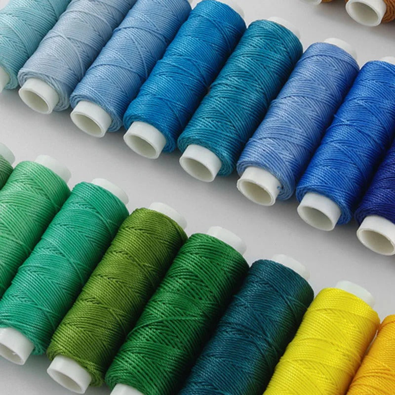 Assorted waxed round thread spools in blues, greens, and yellow