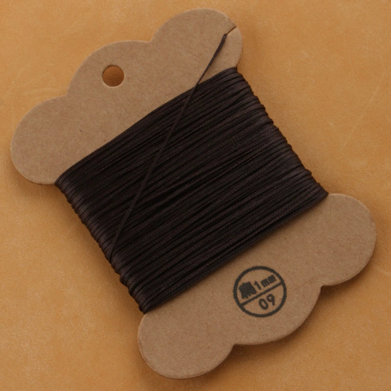Waxed polyester thread spool in black on cardboard card