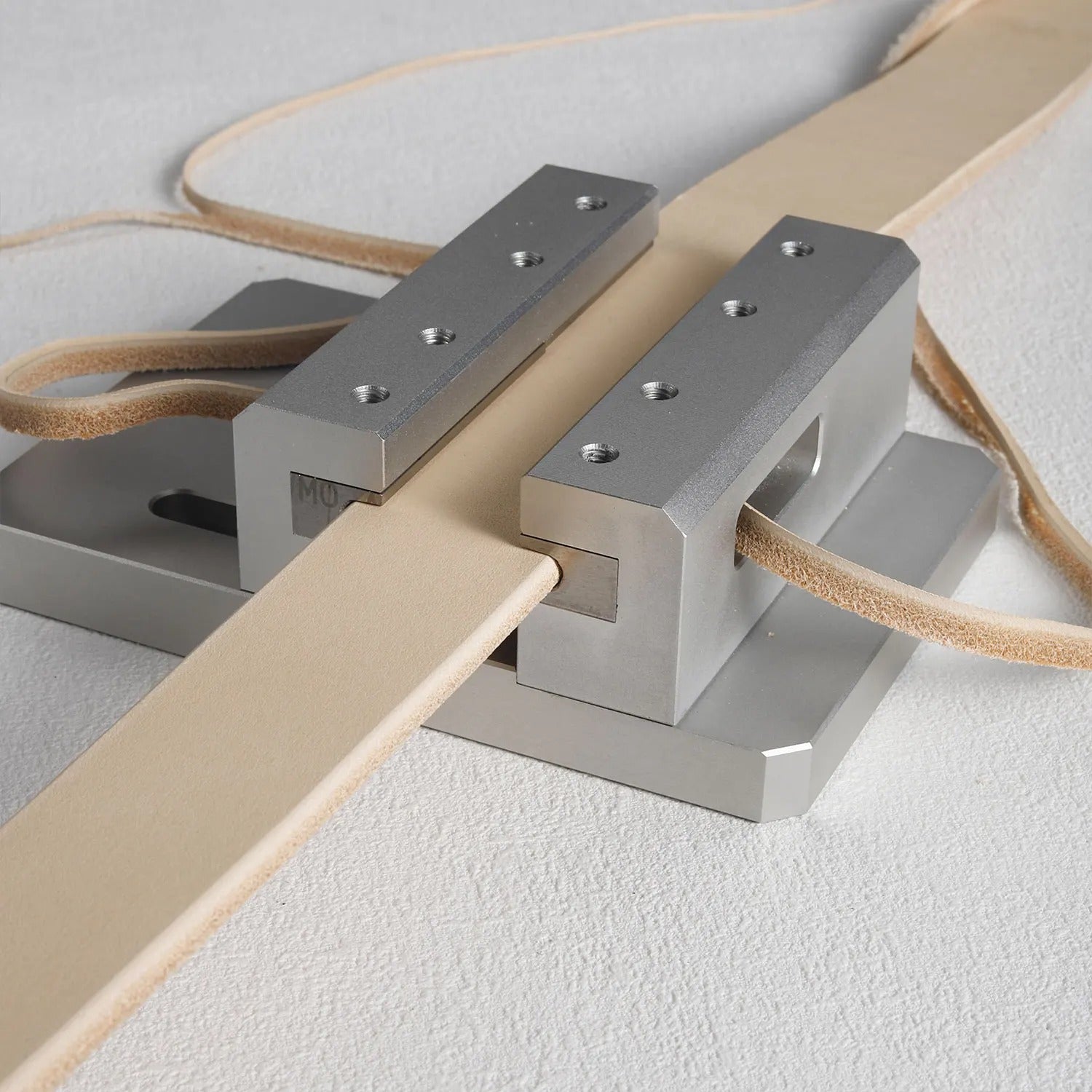 Belt edge trimmer with metal guides holding a leather belt strip