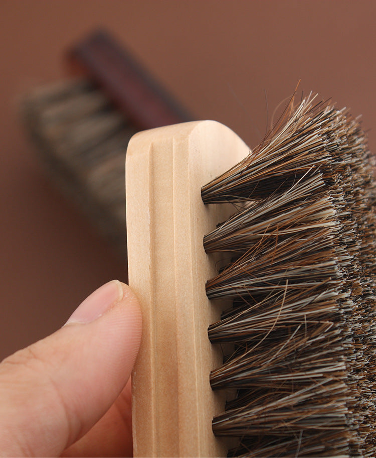 Horsehair brush with wooden base and mixed light-dark bristles, close-up