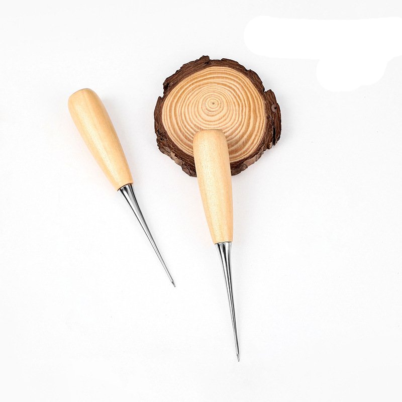 Leather scratch awls with light wood handles and pointed metal tips, with wood slice