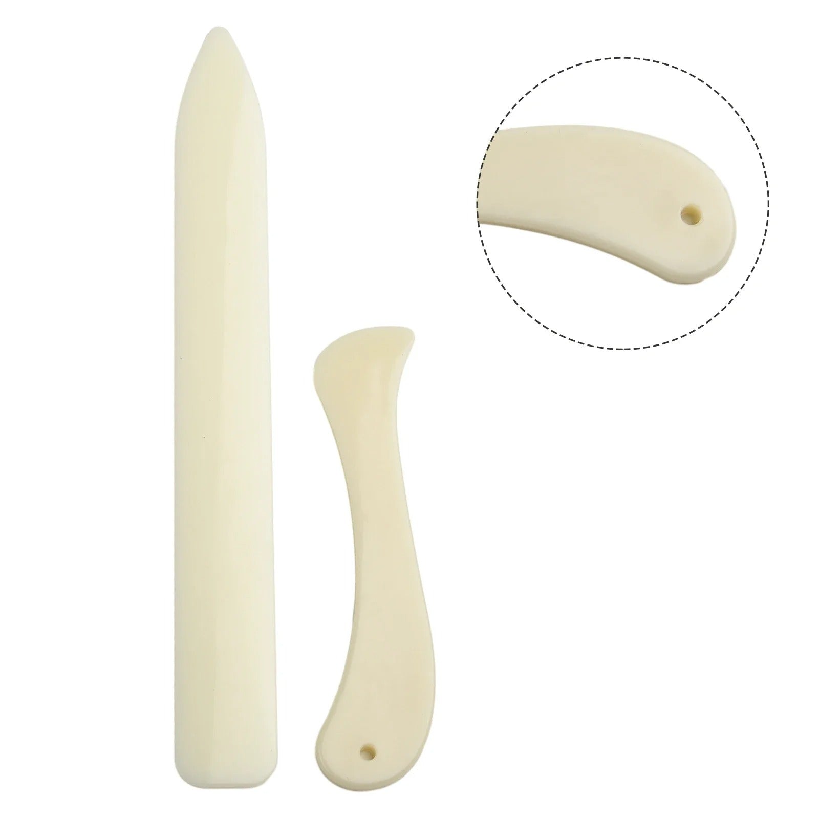 Two cream leather bone folders with curved profile and small hole detail