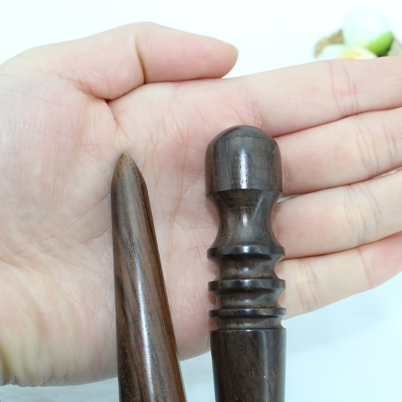 Sandalwood edge burnisher in hand, close-up of dark wooden tip and ridged collar
