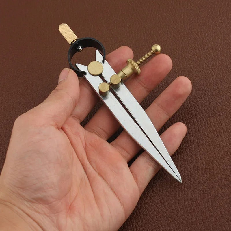 Wing divider tool with lockable adjustment held in hand, brass posts and black ring