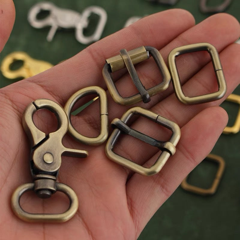 Bag hardware set held in hand: square rings, D-rings, and swivel hardware