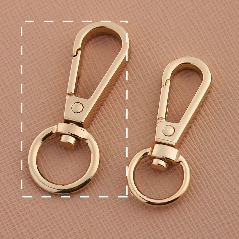 Swivel lobster claw hook buckle hardware, two light gold-tone metal hooks with swivel rings