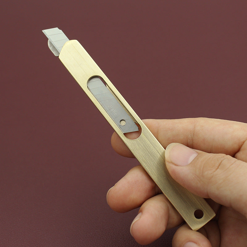 Leather line cutter held in hand, wooden handle with metal blade and white guide