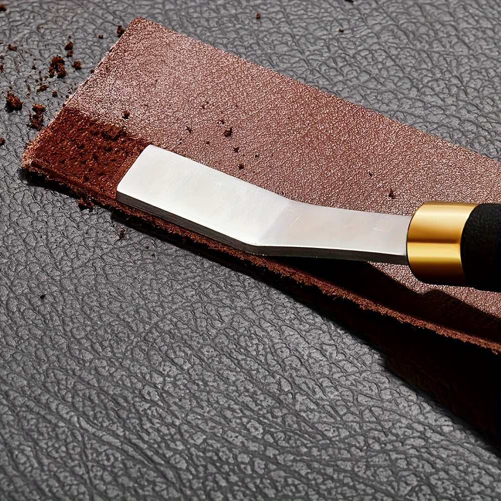 Leather stropping tool blade with black handle, gold ferrule, on dark leather strap