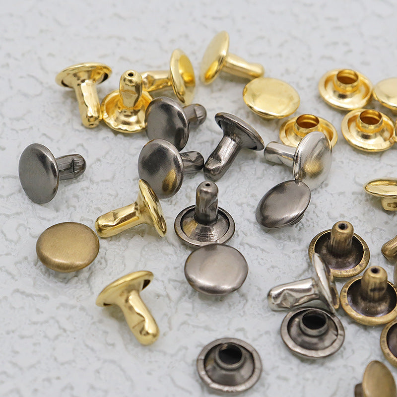 Close-up of mixed double-cap leather rivets with brass and silver metal caps