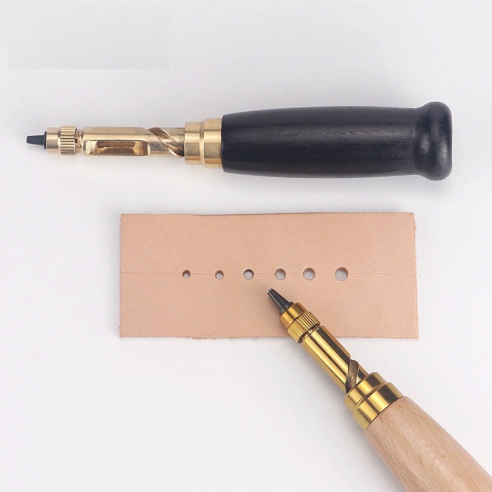 Rotary leather punch tool with wooden handle punching holes in tan leather
