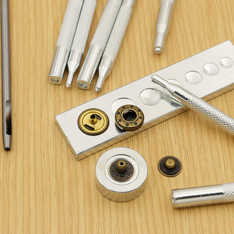 Snap-button die parts with yellow rivets and silver punch setter tools