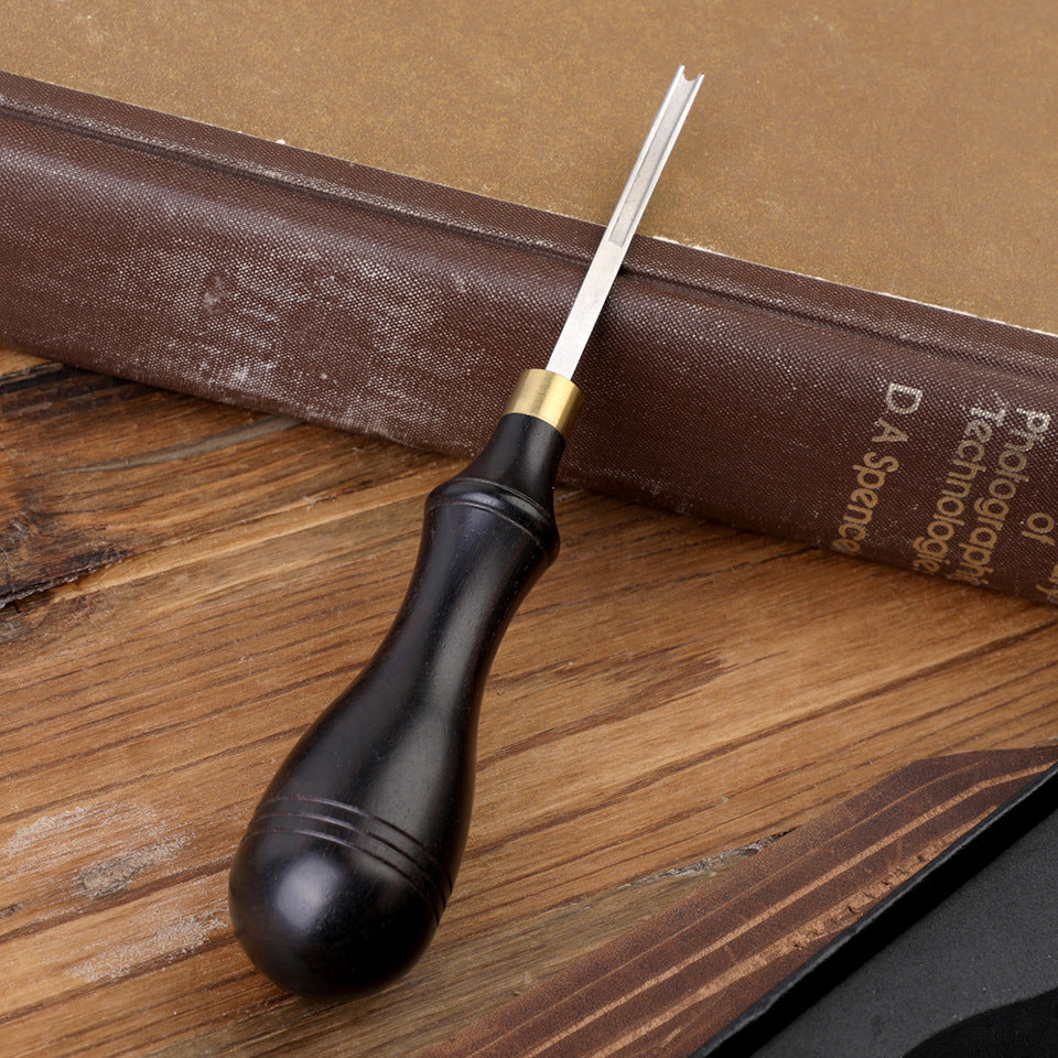 Leather edge beveler with dark wooden handle and wide straight metal blade