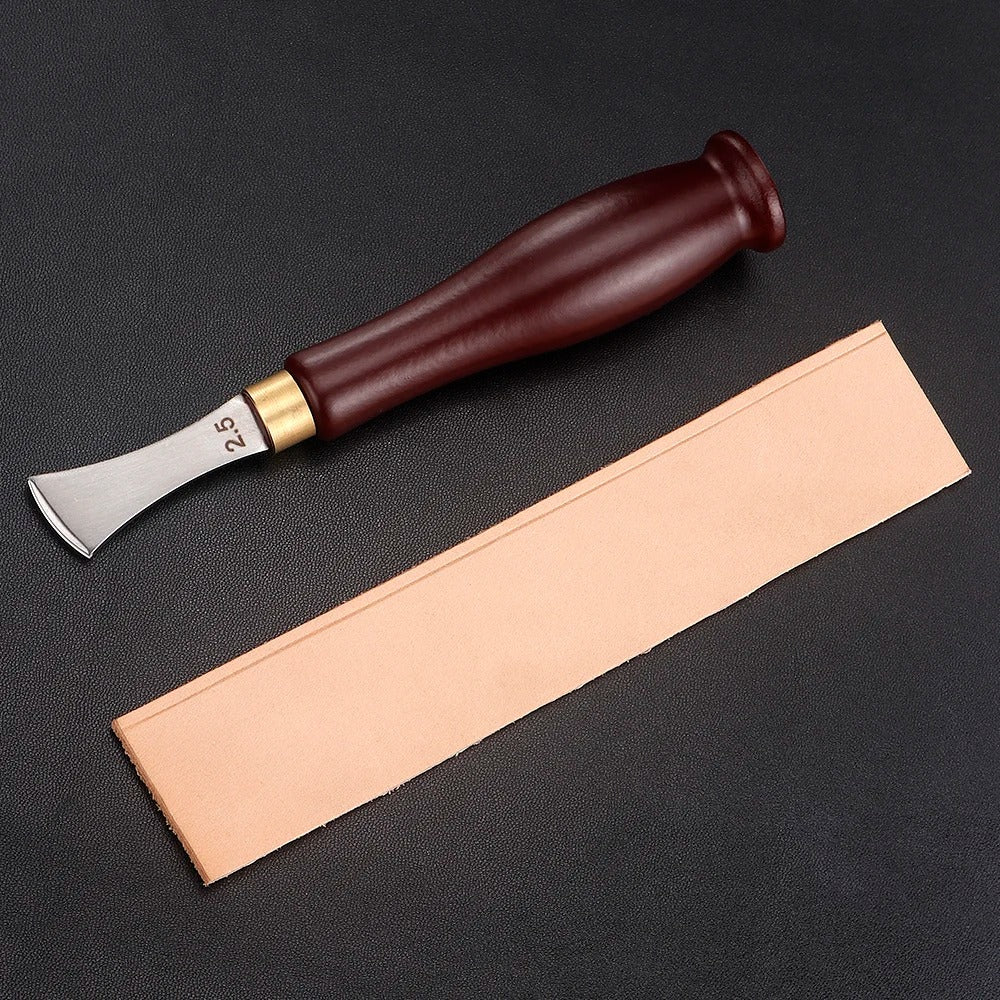 Leather edge creaser tool beside a tan leather strip for shaping an edge