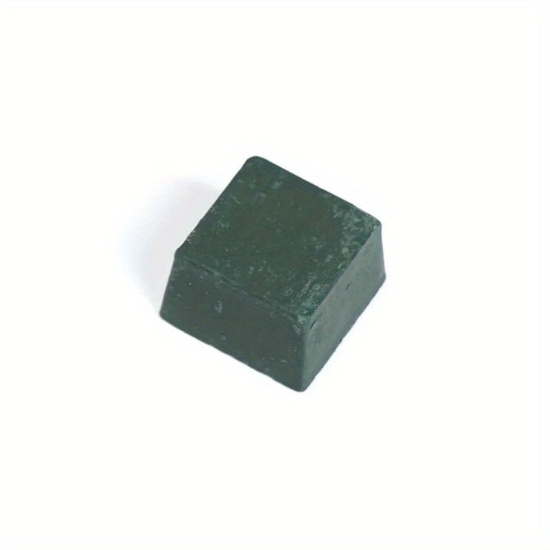 Small green sharpening compound block with worn, textured surface