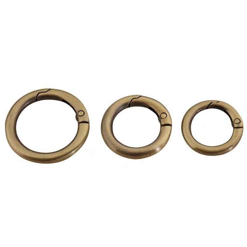 Three bronze-colored metal spring open split rings with pin connector