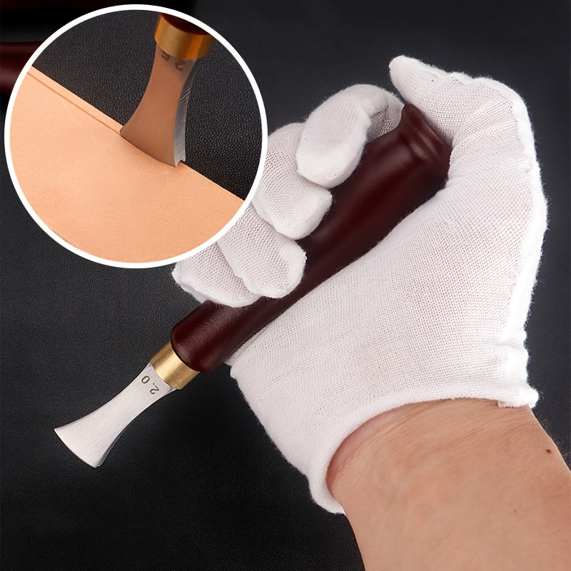 Leather edge creaser tool in a gloved hand, shaping a leather edge with metal blade